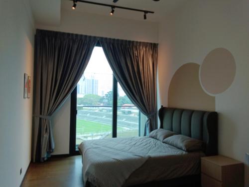a bedroom with a bed and a large window at Opus Residence Kuala Lumpur in Kuala Lumpur