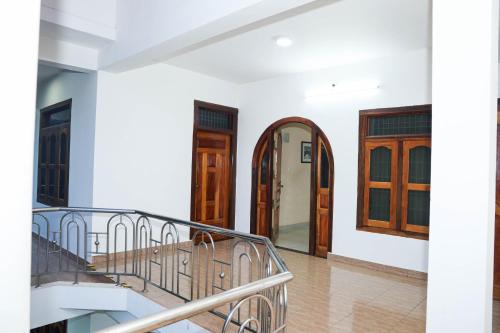 a staircase in a house with wooden doors at SATK INN Jaffna, Kokkuvil in Kokkuvil East