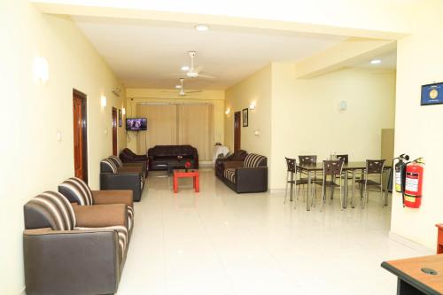 a living room with couches and chairs and a table at SATK INN Jaffna, Kokkuvil in Kokkuvil East