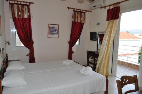 a bedroom with a bed and a large window at Olympion Village Studios in Zakharo