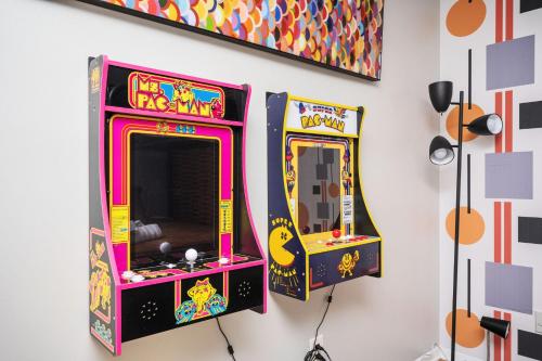 two arcade games are hanging on a wall at Vibrant Family Retreat~Sleeps 8~2 Kings~ Game Room in Snellville