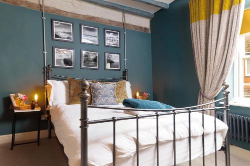 a bedroom with blue walls and a metal bed at Boutique Fisherman's Cottage in Old Town in Scarborough