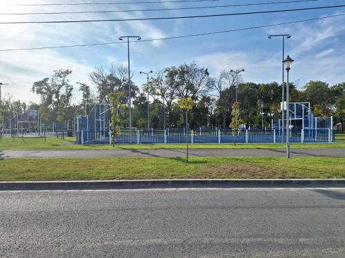 a park with a blue fence and a playground at Casa de langa lac in Oradea