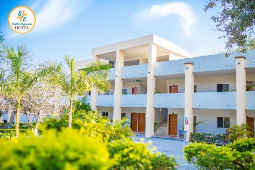 a white building with palm trees in front of it at Hotel Santa Engracia in Ciudad Valles