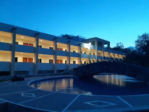 a building with a bridge in front of a pond at Hotel Santa Engracia in Ciudad Valles