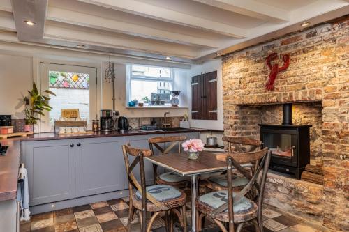 a kitchen with a table and a brick wall at Boutique Fisherman's Cottage in Old Town in Scarborough