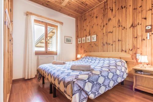 サン・ゼーノ・ディ・モンターニャにあるCasa Bella Vistaの木製の壁のベッドルーム1室(ベッド1台付)