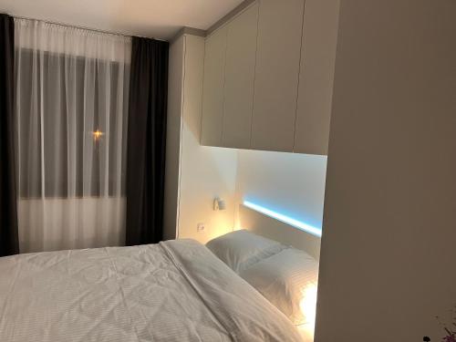a bedroom with a white bed and a window at Jahorina Apartment4Two in Jahorina