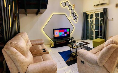 a living room with two chairs and a tv at SSR 41 SEREMBAN TOWN 4R3B homestay in Seremban