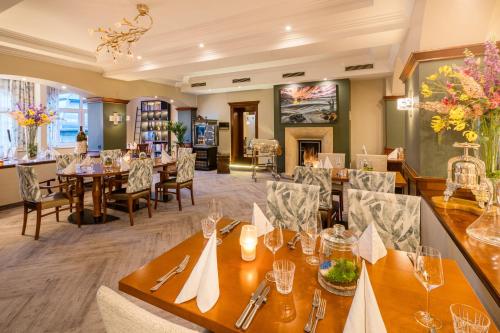 a dining room with tables and chairs and a fireplace at Hotel Rech in Brilon