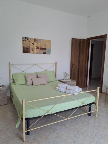 サン・ジョヴァンニ・スエルジュにあるLa Casa Di Donato E Mariaのベッドルーム1室(緑のシーツとピンクの枕が備わるベッド1台付)