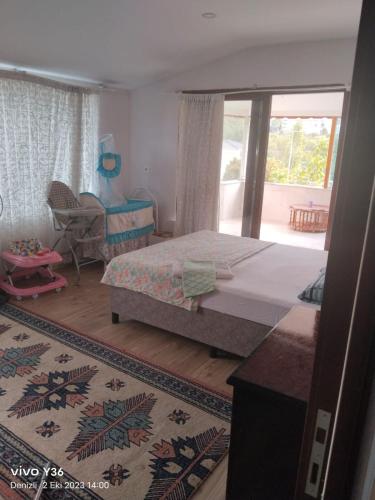 a bedroom with a bed and a chair and a window at RAİNFORT NAR GÜMÜScaY in Kayı