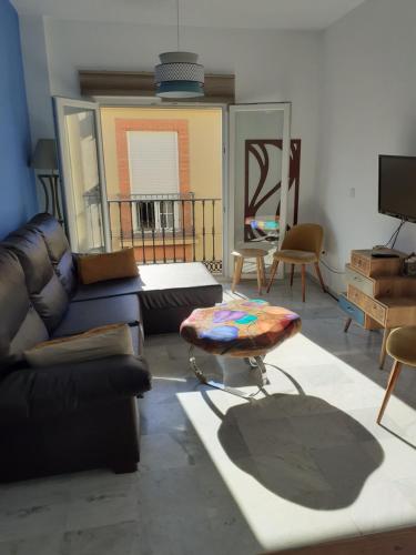 salon z kanapą i stołem w obiekcie Centro Histórico con Balcón 2 Bedrooms w Maladze