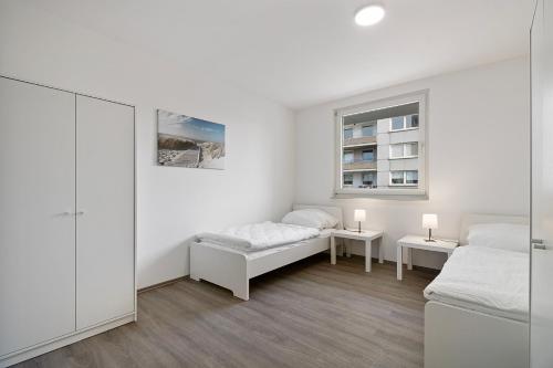 a white room with two beds and a window at Wohnung mit Balkon in Wuppertal in Wuppertal