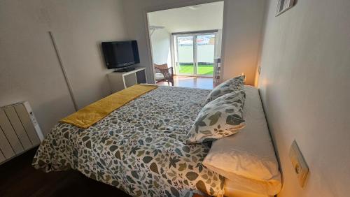 a bedroom with a bed and a tv in it at Ático Magdalena - WIFI in Ferrol