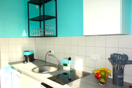 uma cozinha com um lavatório e uma bancada em HAPPY HOMES - Up to 5 - Küche - W-LAN - Netflix - Honig - Balkon em Nidda