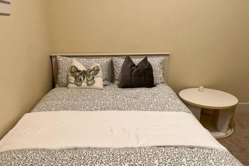 a bedroom with a bed with pillows and a table at Entire Guest Suite - 1 bedroom w/ Private Entrance in Surrey