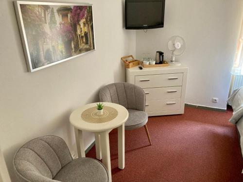 a room with two chairs and a table and a dresser at Penzion Moravia - free parking in the city center in Mikulov