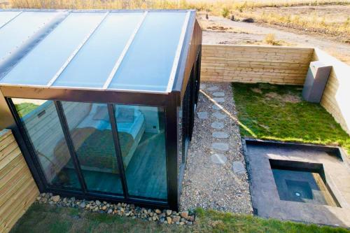 a house with a glass roof on top of it at Glass roof lodge with private hot tub in Reykholt