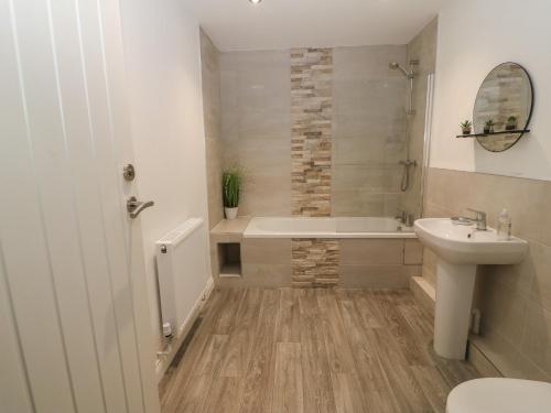 łazienka z wanną, umywalką i toaletą w obiekcie 1 Dulas Apartments w mieście Abergele