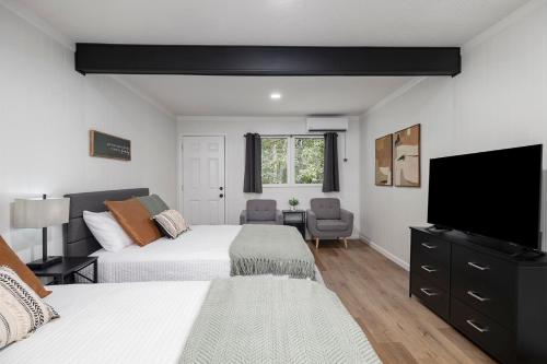 a bedroom with two beds and a flat screen tv at The Lofts on Indian Point - Near Silver Dollar City in Branson
