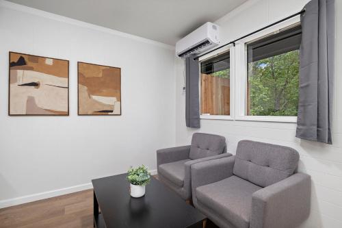 a living room with two chairs and a table at The Lofts on Indian Point - Near Silver Dollar City in Branson