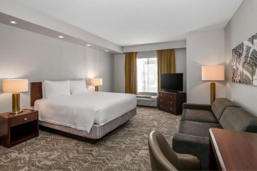 a hotel room with a bed and a couch at SpringHill Suites Phoenix Glendale Sports & Entertainment District in Glendale