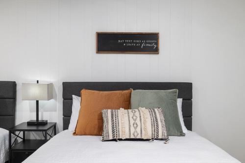 a bed with pillows and a sign on the wall at The Lofts on Indian Point - Near Silver Dollar City in Branson