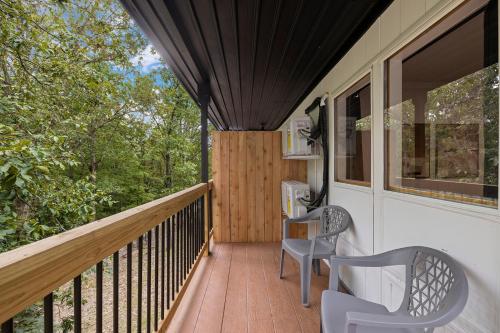 a porch with two chairs and a wooden deck at The Lofts on Indian Point - Near Silver Dollar City in Branson