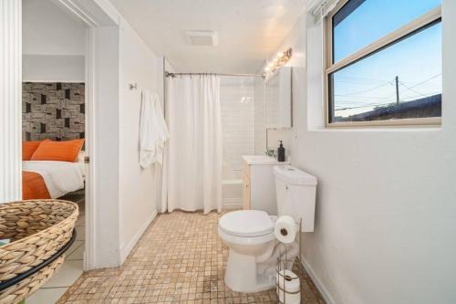 uma casa de banho branca com um WC e uma janela em 5 Bd 1940's Oasis - Pool - Lounge - Games em Tucson