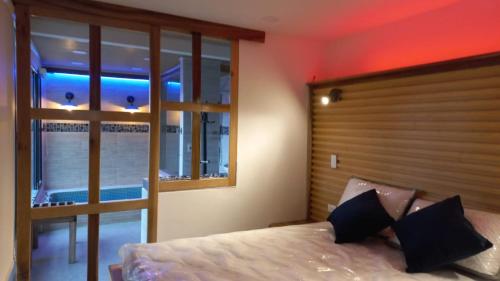 ein Schlafzimmer mit einem Bett und einem großen Fenster in der Unterkunft Los Ocobos Libano Tolima - Suite, Hostal y Restaurante in Líbano