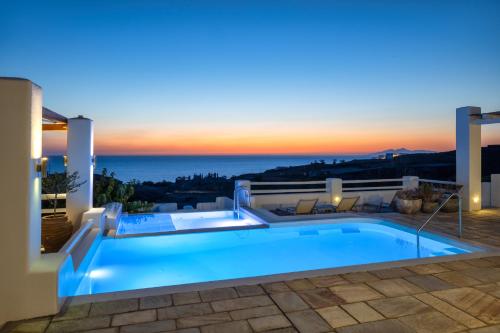 une villa avec une piscine la nuit dans l'établissement Anema Boutique Hotel & Villas Santorini, à Vourvoúlos