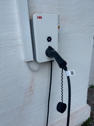 a black cord plugged into a lightswitch on a wall at Bergbach in Ramsau