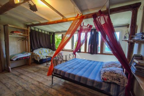 a bedroom with two beds and a canopy bed at Zornica Guest House in Chepelare