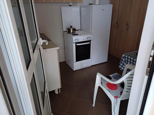 a small kitchen with a stove and a refrigerator at Sobe Kata - atomska banja Gornja Trepca in Čačak