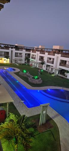 a large apartment building with a swimming pool in front of it at Condominio Boas Vistas in Aracati