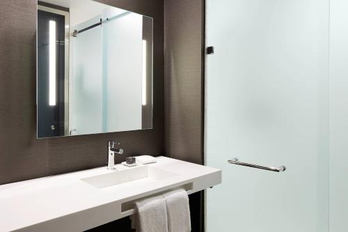 a bathroom with a white sink and a mirror at AC Hotel by Marriott Miami Aventura in Aventura