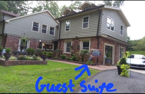 a house with a guest suite and a car in the yard at Chans Lakeside Hideaway in Stone Mountain