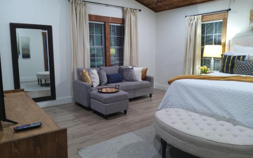 ein Schlafzimmer mit einem Bett, einem Sofa und einem Spiegel in der Unterkunft Chans Lakeside Hideaway in Stone Mountain