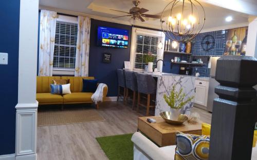 sala de estar con paredes azules y sofá amarillo en Chans Lakeside Hideaway en Stone Mountain