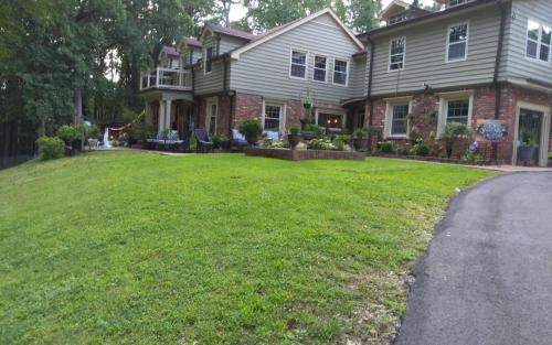 a house with a green lawn in front of it at Chans Lakeside Hideaway in Stone Mountain