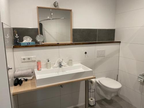 a white bathroom with a sink and a toilet at Hotel Alte Navigationsschule in Rhauderfehn