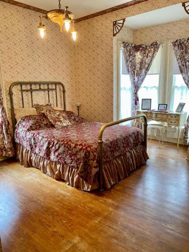 a bedroom with a bed and a table in it at Pansy’s Parlor Bed & Breakfast in Golden