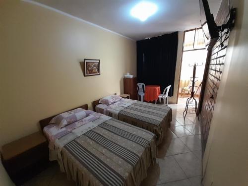 a room with two beds in a room with a window at Nasca Trails B&B in Nazca