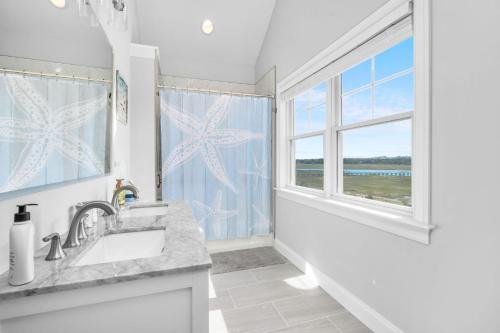a white bathroom with a sink and a window at 114 Salt Marsh Road East Sandwich Seaglass in East Sandwich