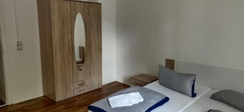 - une chambre avec un lit et une armoire en bois dans l'établissement Apolo 3, à Chemnitz