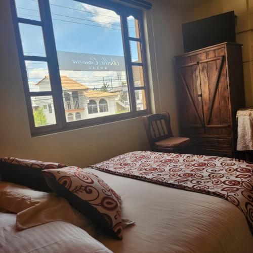 a bedroom with two beds and a large window at Hotel Bella Casona in Riobamba