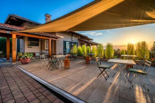 a patio with a table and chairs and a table and chairs at La Rosa Gialla Bio Apartments & rooms in Barolo