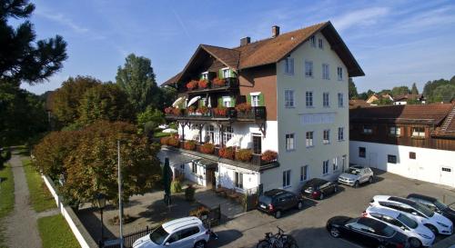 a large white building with cars parked in a parking lot at Hotel Wittelsbacher Hof in Utting am Ammersee