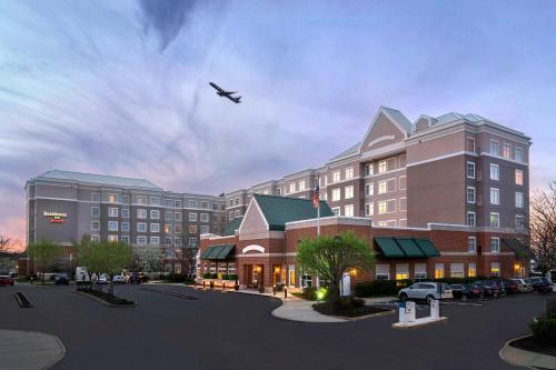 a plane flying over a large building with a parking lot at Residence Inn by Marriott Newark Elizabeth/Liberty International Airport in Elizabeth